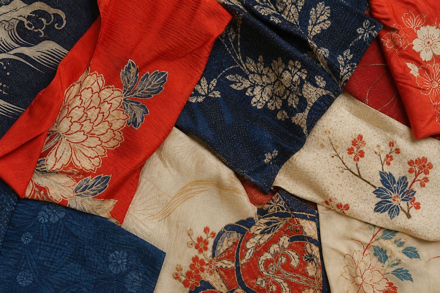 Flat-lay of vintage kimono silk remnants in vermillion, indigo, and cream